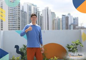 a man giving a thumbs up in front of a city at The Flats Amorsolo in Manila