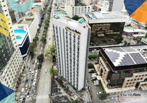 una vista aerea di un grande edificio bianco in una città di The Flats Amorsolo a Manila