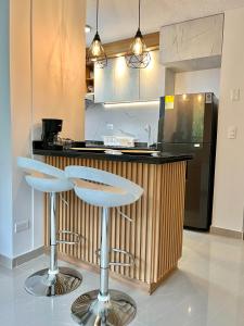 a kitchen with two bar stools in front of a counter at Tranquilidad y lujo en Pereira in Pereira