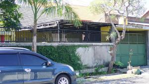 a blue car parked in front of a house at OYO 93784 Kost Bu Eli Syariah in Ngadipuro