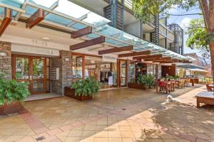 un edificio con un patio con mesas y sillas en Surf at Avalon Beach and Laze on the Private Terrace, en Avalon