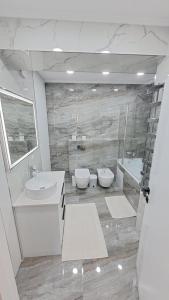 a bathroom with two sinks and a toilet and a tub at Аэропорт-Номера 24/24 . in Chişinău