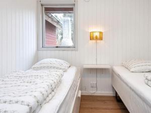 ToftumにあるHoliday Home Koubjerg IIの白いベッドルーム(ベッド2台、窓付)