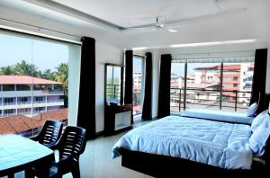MūlkiDWARKA LODGING & BOARDING的一间卧室配有一张床,阳台配有桌椅