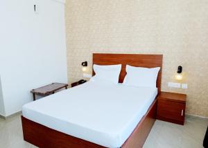 1 dormitorio con 1 cama blanca grande en una habitación en DWARKA LODGING & BOARDING, en Mūlki