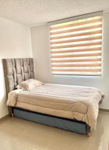 a bed sitting in a bedroom with a window at Tranquilidad y lujo en Pereira in Pereira