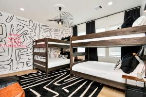 zwei Etagenbetten in einem Zimmer mit einer Wand mit Graffiti in der Unterkunft Paradise Palace Best Rooftop in HTX w Hot Tub in Houston