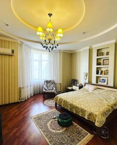 sypialnia z dużym łóżkiem i żyrandolem w obiekcie Saule Guest House w mieście Szymkent