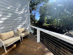 a porch with two chairs and a window at The Tree House Byron Bay in Byron Bay