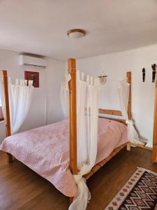 Guest house Kashtata في شابلا: سرير مع ستائر بيضاء في غرفة النوم