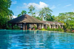 Villa con piscina frente a una casa en Sheridan Boutique Resort Iloilo en Iloilo