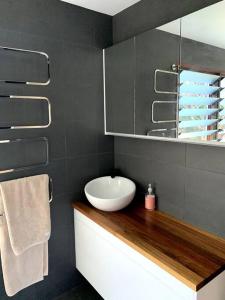 a bathroom with a white sink and a mirror at The Tree House Byron Bay in Byron Bay