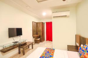 a bedroom with a bed and a tv on a wall at FabHotel Krishna in Nagpur