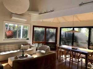 a living room with a couch and a table at The Tree House Byron Bay in Byron Bay