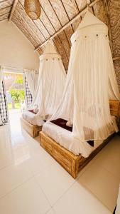 a bedroom with two beds with mosquito nets at Penida Hills in Nusa Penida