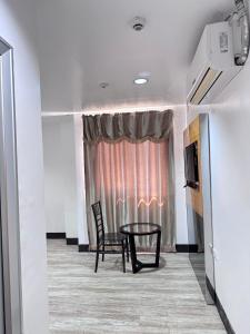 プエルト・プリンセサにあるJeamco Royal Hotel-Palawanの窓際のテーブルと椅子が備わる部屋