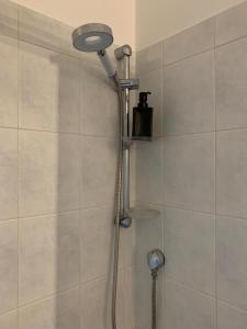 y baño con ducha con cabezal de ducha. en Erzelli's House Apt B con 2 camere by SMART-HOME en Génova