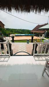 Blick auf eine Terrasse mit einem Tisch und Stühlen in der Unterkunft Penida Hills in Nusa Penida