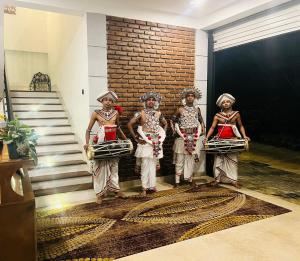 un groupe de quatre personnes debout dans une pièce dans l'établissement Green Heaven Resort Kandy, à Kandy