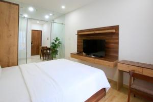 a bedroom with a bed and a flat screen tv at Cityhouse - Nguyễn Đình Chiểu in Ho Chi Minh City