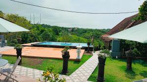 een achtertuin met een zwembad en een huis bij Penida Hills in Nusa Penida