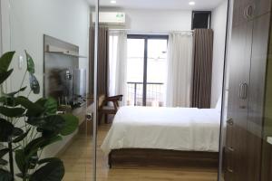 a bedroom with a bed and a sliding glass door at Cityhouse - Nguyễn Đình Chiểu in Ho Chi Minh City