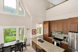 a kitchen with a counter top and some windows at Scenic 3BR Penthouse Suite w/ Rooftop Lake View in Harrison Hot Springs