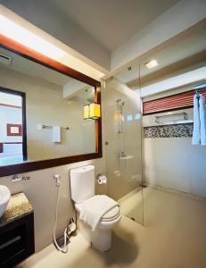 a bathroom with a toilet and a glass shower at Sheridan Boutique Resort Iloilo in Iloilo City