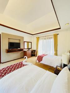 a hotel room with two beds and a television at Sheridan Boutique Resort Iloilo in Iloilo City