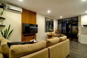 a living room with a couch and a flat screen tv at La Casa Deluxe - short escape from pererenan beach in Munggu