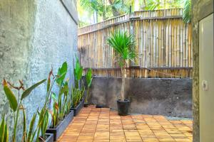 a courtyard with potted plants and a wooden fence at La Casa Deluxe - short escape from pererenan beach in Munggu