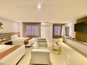 ein Hotelzimmer mit 2 Betten und einem Sofa in der Unterkunft SM Tower Hotel and Convention Berau in Tanjungredep