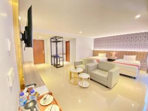 ein Hotelzimmer mit einem Bett und einem Wohnzimmer in der Unterkunft SM Tower Hotel and Convention Berau in Tanjungredep