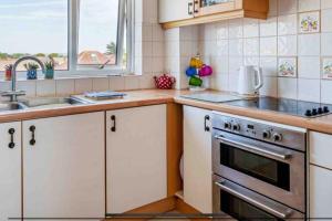 a kitchen with a stove and a sink at 22 rooftop Penthouse ! in South Hayling