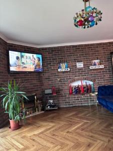 a living room with a tv and a brick wall at 22 rooftop Penthouse ! in South Hayling