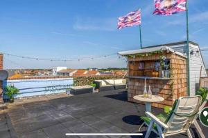 a patio with a table and two chairs and flags at 22 rooftop Penthouse ! in South Hayling