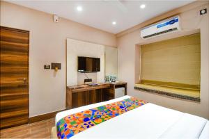ein Schlafzimmer mit einem Bett und einem TV in einem Zimmer in der Unterkunft FabHotel Prime Jalsa in Kalkutta