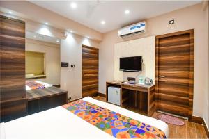a hotel room with two beds and a tv at FabHotel Prime Jalsa in Kolkata