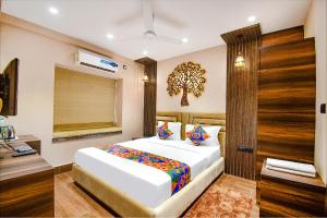 1 dormitorio con 1 cama con un árbol en la pared en FabHotel Prime Jalsa, en Calcuta