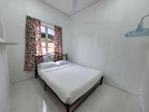 a small bedroom with a bed and a window at Cantik-La Homestay 3 Bilik Kuala Terengganu in Bukit Payong