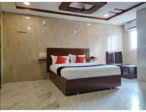 a bedroom with a large bed with red pillows at Hotel Grand Inn, Warangal in Warangal