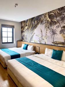 Milash Boutique Hotel في ها لونغ: سريرين في غرفة الفندق مع لوحة جدارية