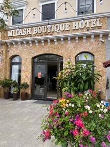 Milash Boutique Hotel في ها لونغ: فندق بوتيك mitzitz مع الزهور أمامه