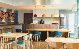 un ristorante con tavoli in legno e sedie blu di Park City Inn & Hostel a Yonghe
