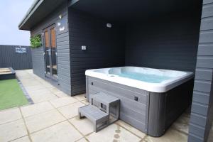a jacuzzi tub in the backyard of a house at Beachway in Prestatyn