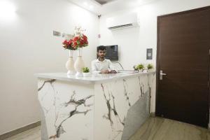 a man sitting at a marble counter in a room at Hotel Diamond Home Stay In Jangpura Bhogal Near Nizamuddin Railway Station in New Delhi