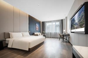 a hotel room with a bed and a flat screen tv at Atour Hotel Chengdu Jinhua Wanda Liulichang in Chengdu +24 photos