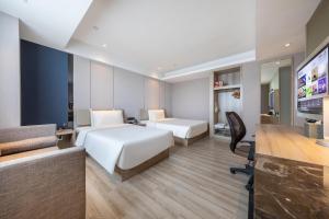 南京的住宿－南京总统府亚朵酒店，酒店客房设有两张床和一台平面电视。