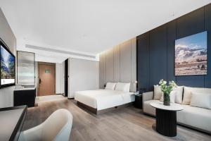 a hotel room with a bed and a couch at Atour Hotel Chengdu Jinhua Wanda Liulichang in Chengdu