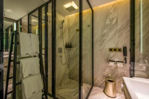 La salle de bains est pourvue d'une douche et d'un lavabo. dans l'établissement Atour S Hotel Guangzhou Beijing Road Tianzi Wharf, à Canton